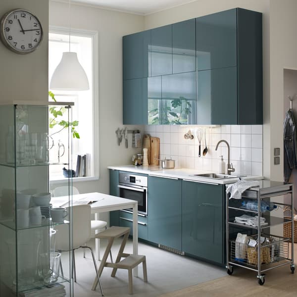 A small, modern kitchen with white walls and splash-back and high-gloss grey-turquoise KALLARP doors.