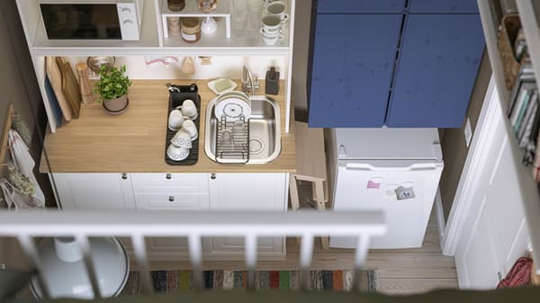 A small one-room home can be seen from above, with a white ÖNNERUP kitchenette next to blue cabinets and a LAGAN fridge.