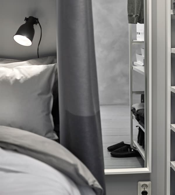 A small reading lamp sits on the wall at the head of the bed.