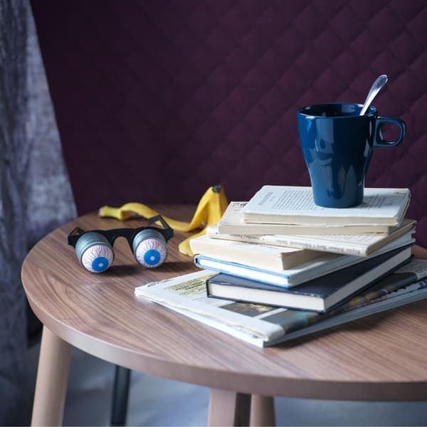 A small side table with a stack of books and a cup of coffee.