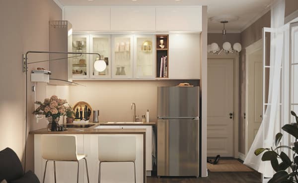 A small white kitchen consisting of a refrigerator and base cabinets, drawers, a worktop and a wall cabinet.