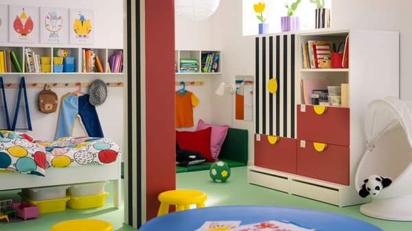 A SMÅSTAD/PLATSA storage combination with three drawers stands opposite a pillar in a child’s room with a green floor.