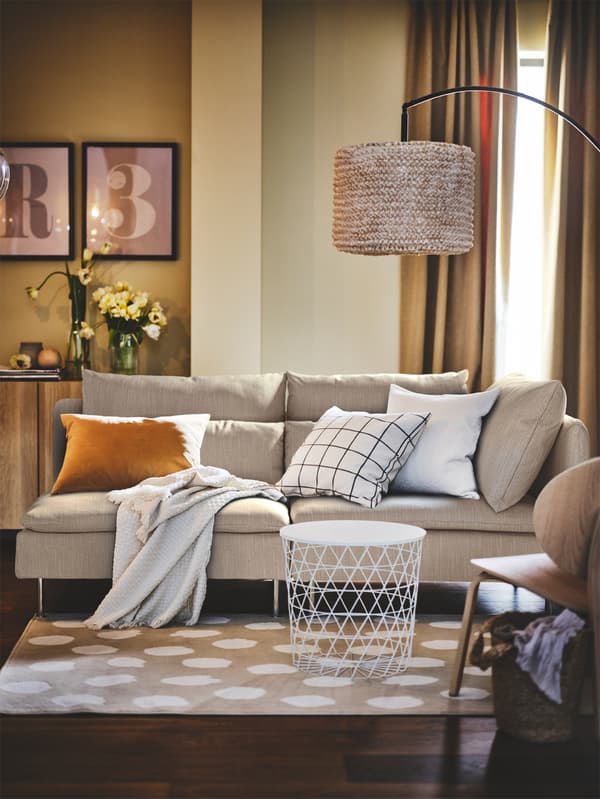 A SÖDERHAMN 3-seat sofa with open end, with some extra cushions lying on it, stands in a living room.