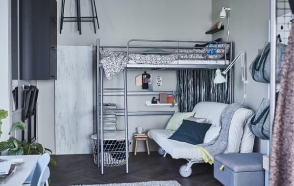 A sofa on castors under a loft bed in a sleeping area.