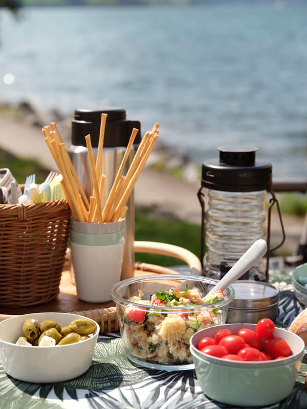 A solar lamp and three food containers filled with food on a table