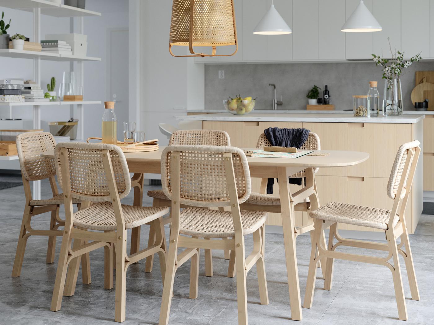 A spacious light kitchen with VOXLÖV light-bamboo table and chairs forming a dining area beneath a KNIXHULT bamboo pendant.