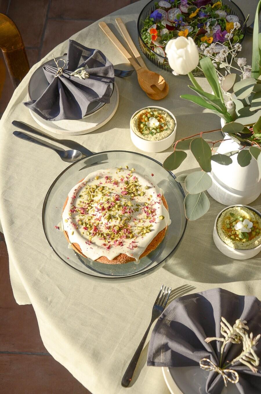 A springlike table arrangement whit a cake in the middle.