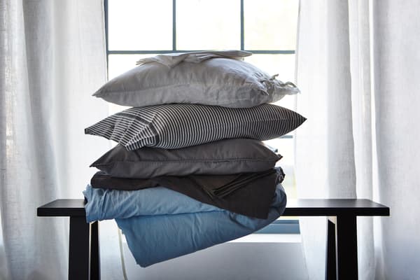 A stack of pillows and bed textiles in different materials that help regulate sleep temperature.