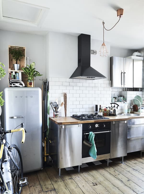 A stainless-steel kitchen with wooden floor.