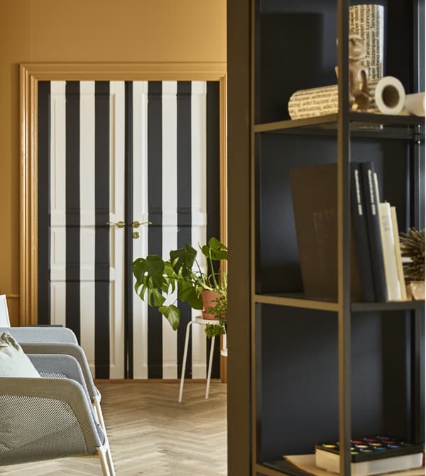 A stand-alone wall with a workspace sits in the middle of a living room.