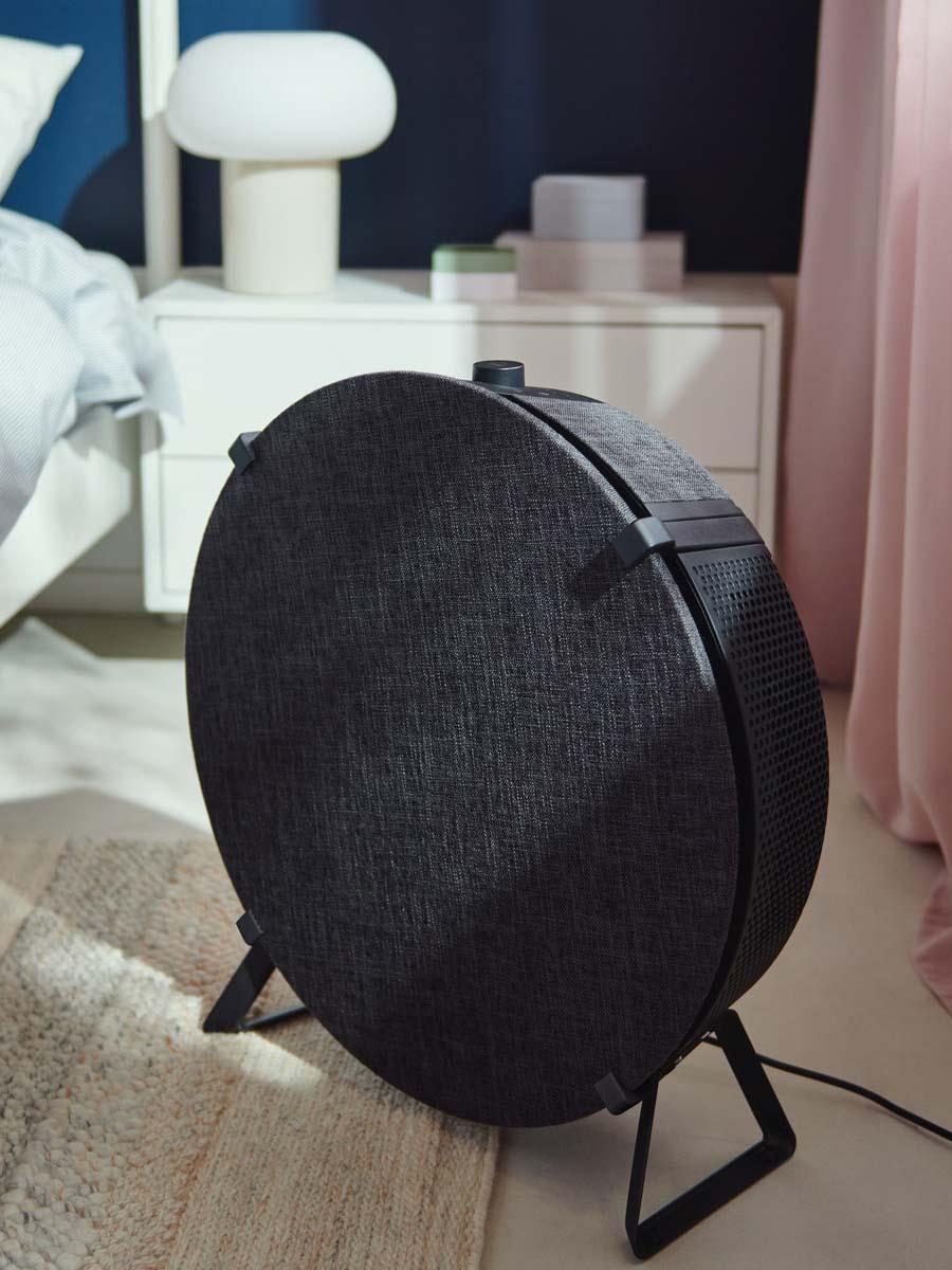 A STARKVIND air purifier standing on a floor of brightly-lit bedroom.