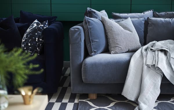 A STOCKHOLM 2017 blue plush sofa with cushions and throws.