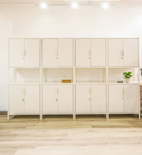 A storage area featuring four white cabinets with another four cabinets stacked on top of each other.