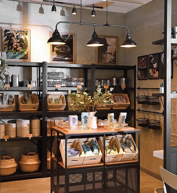 A storage area showcasing black shelves of various coffee bean packets neatly placed in baskets and boxes.