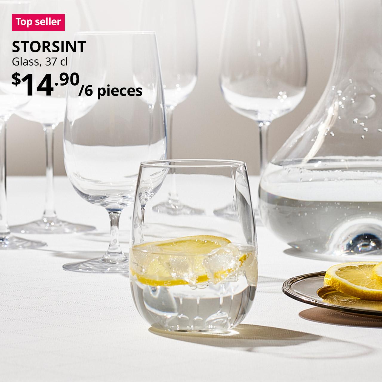A STORSINT clear glass in 37 cl in a dining room setting. A red "Top seller" label is on the top left of image, with black text below that reads: STORSINT, Glass, 37 cl. Price $14.90 / 6 pieces.
