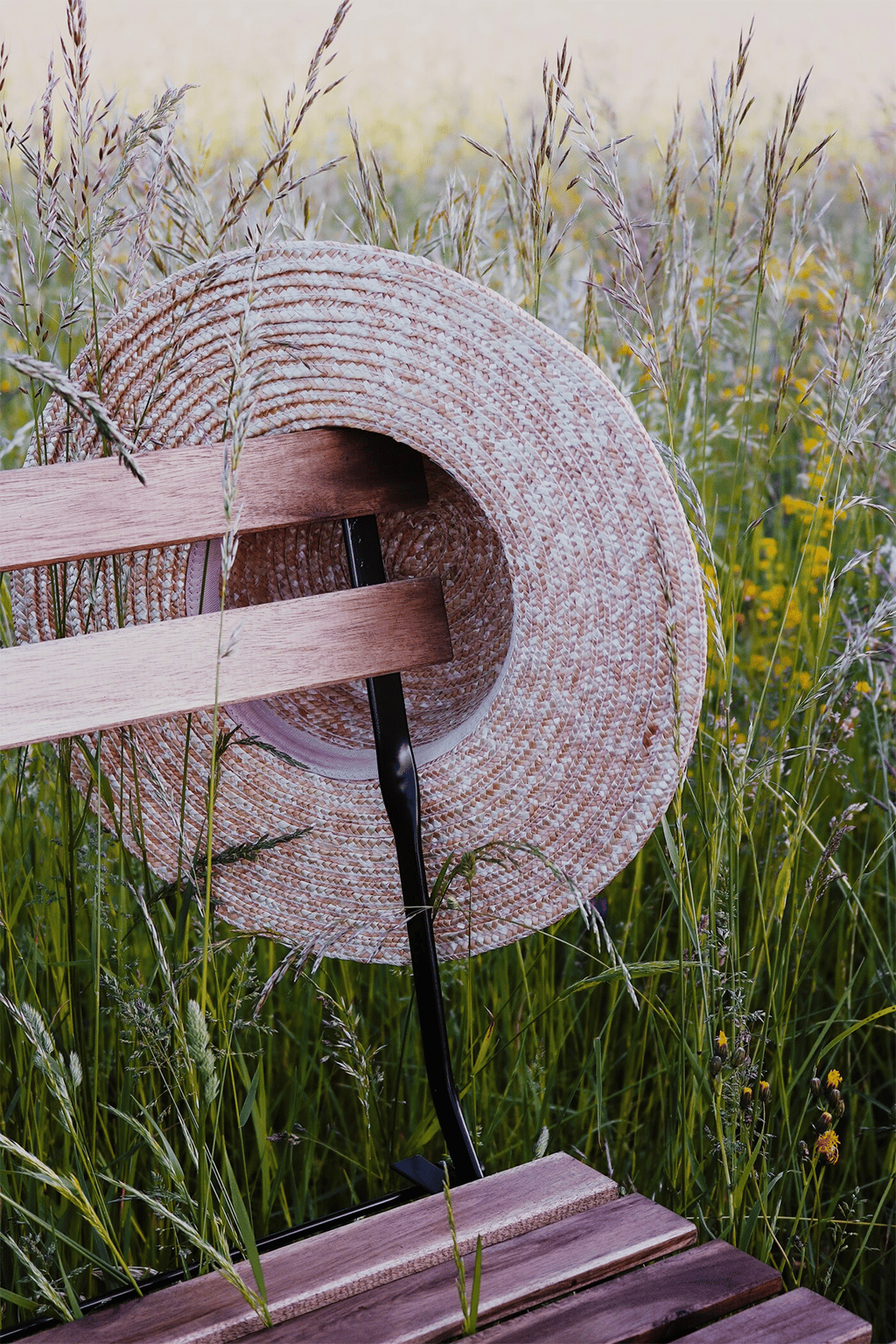 A straw hat over the back of a chair