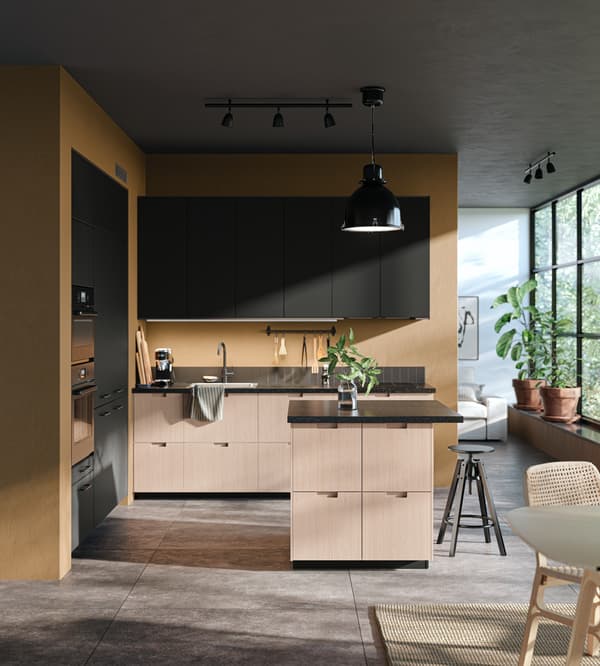 A sundrenched kitchen with a combination of FRÖJERED and KUNGSBACKA fronts, a DALFRED bar stool in front of a kitchen island.