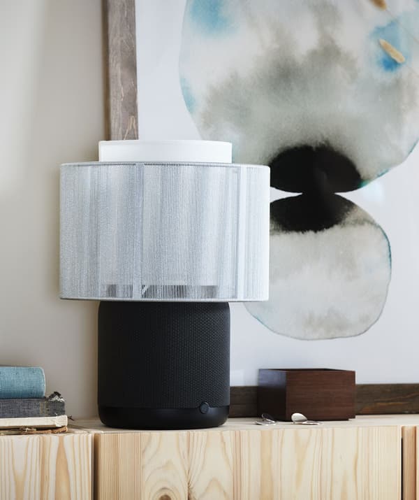 A SYMFONISK Wi-Fi speaker lamp on a pine sideboard.