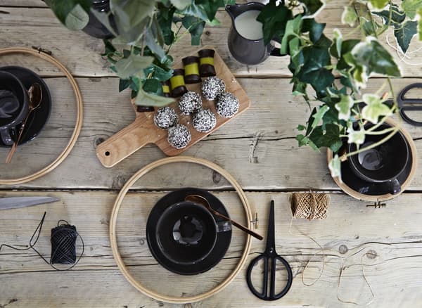 A table full of crafting tools, teacups and snacks.