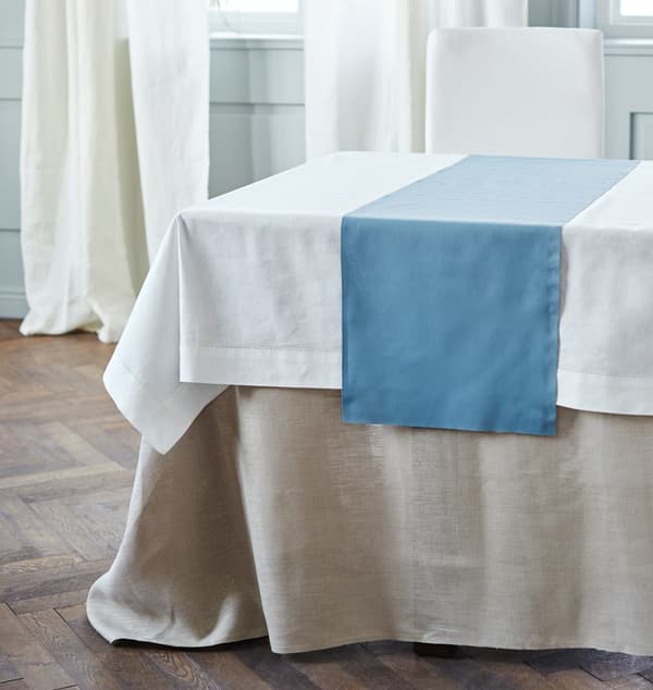 A table is dressed with three layers of textiles of different lengths.