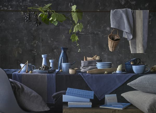 A table setting with ceramics and textiles in a blue colour palette.