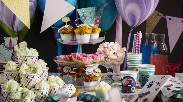 A table with party supplies and sweet treats atop it