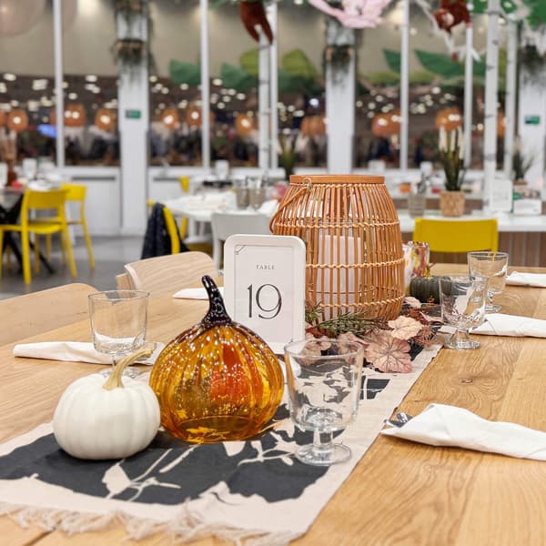 A tablescape with pumpkin decorations and a number 19 table number.