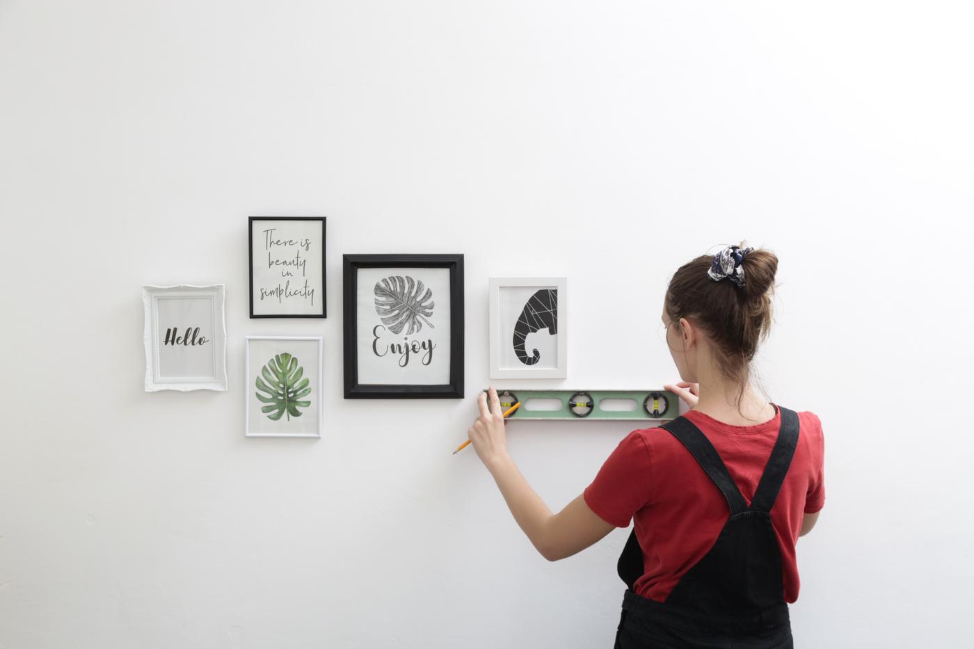 A Task Rabbit tasker using a level to check if a picture frame is alligned.