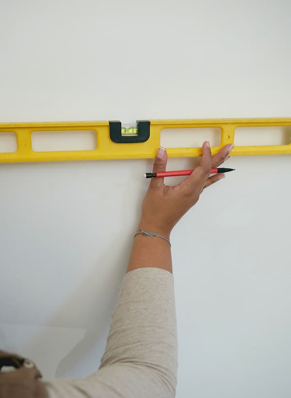 A Taskrabbit Tasker checking a wall with a level