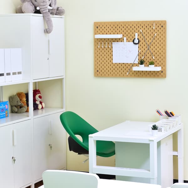 A teacher area in a childcare centre featuring a desk and cabinets behind.