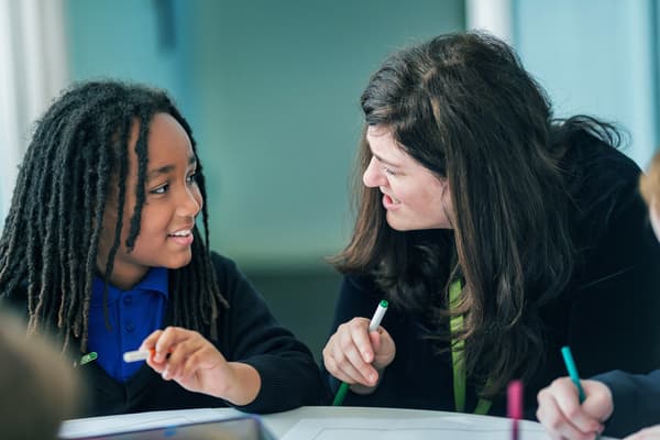 A teacher helping out a kid with homeworks