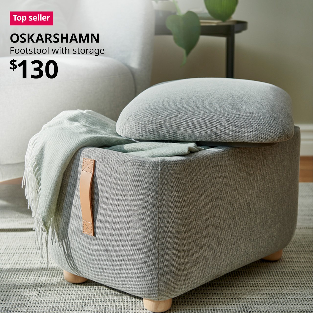 A tibbleby beige/grey OSKARSHAMN footstool with storage placed infront of a armchair in a living room setting. A red "Top seller" label is on the top left of image, with black text below that reads: OSKARSHAMN, Footstool with storage. Price $130"