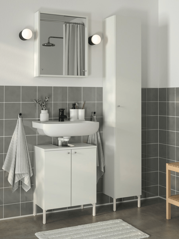 A tiled bathroom with a BJÖRKÅN single wash-basin on the wall above a NYSJÖN wash-basin base cabinet with 2 doors.