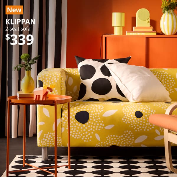 A tingetorp yellow/white with floral pattern 2-seat KLIPPAN sofa is placed next to a bright orange GLADOM in a living room setting. An orange "NEW" label is on the top left of the image with white text that reads: KLIPPAN, 2-seat sofa, $339.