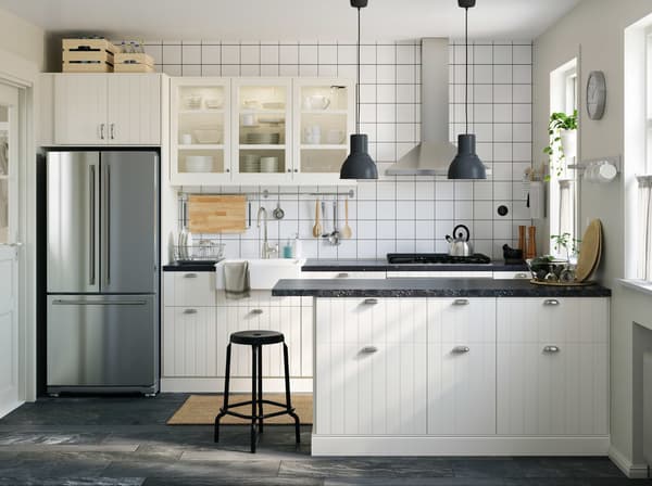 A traditional off-white kitchen with a combination of SEKTION/HITTARP glass doors, light coming in from the window.