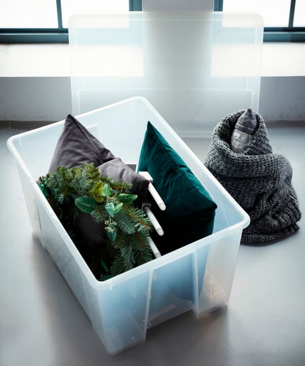 A transparent SAMLA storage box filled with cushions.