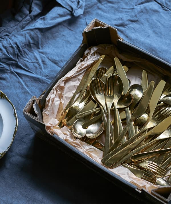 A tray of gold-coloured cutlery.