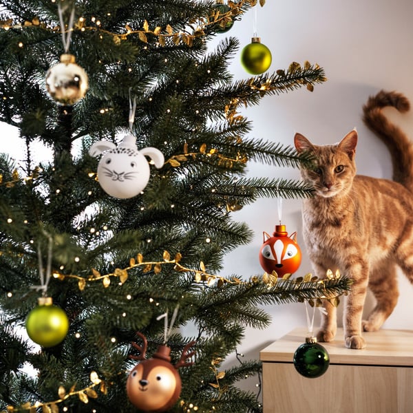 A tree is decorated with ornaments in a living room setting
