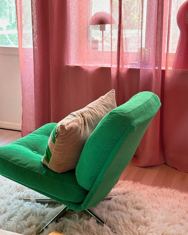 A trendy color combination - a green armchair in a pink room.