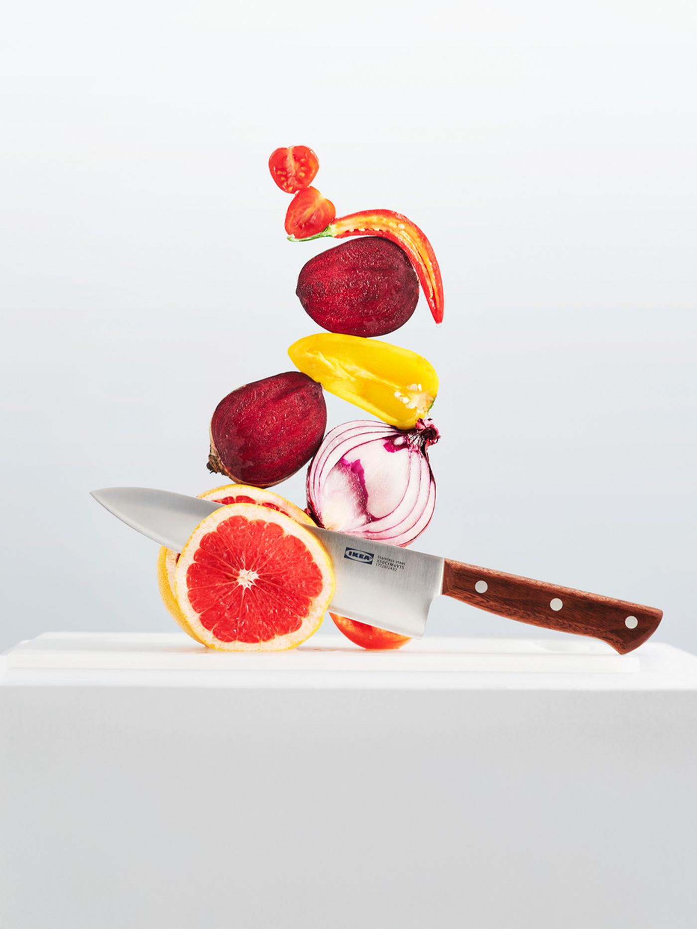 A VARDAGEN knife cutting through a grapefruit with several other vegetables stacked on top of it all.
