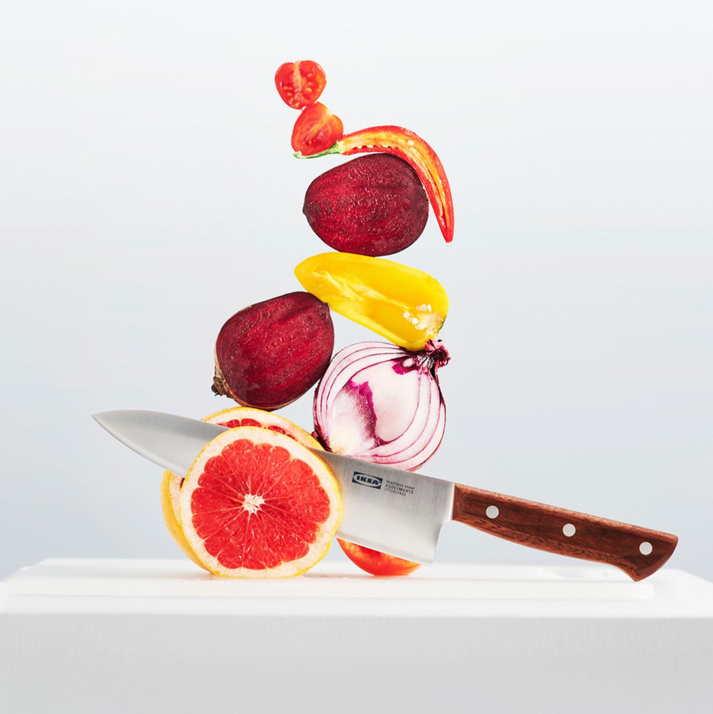 A VARDAGEN knife cutting through a grapefruit with several other vegetables stacked on top of it all.