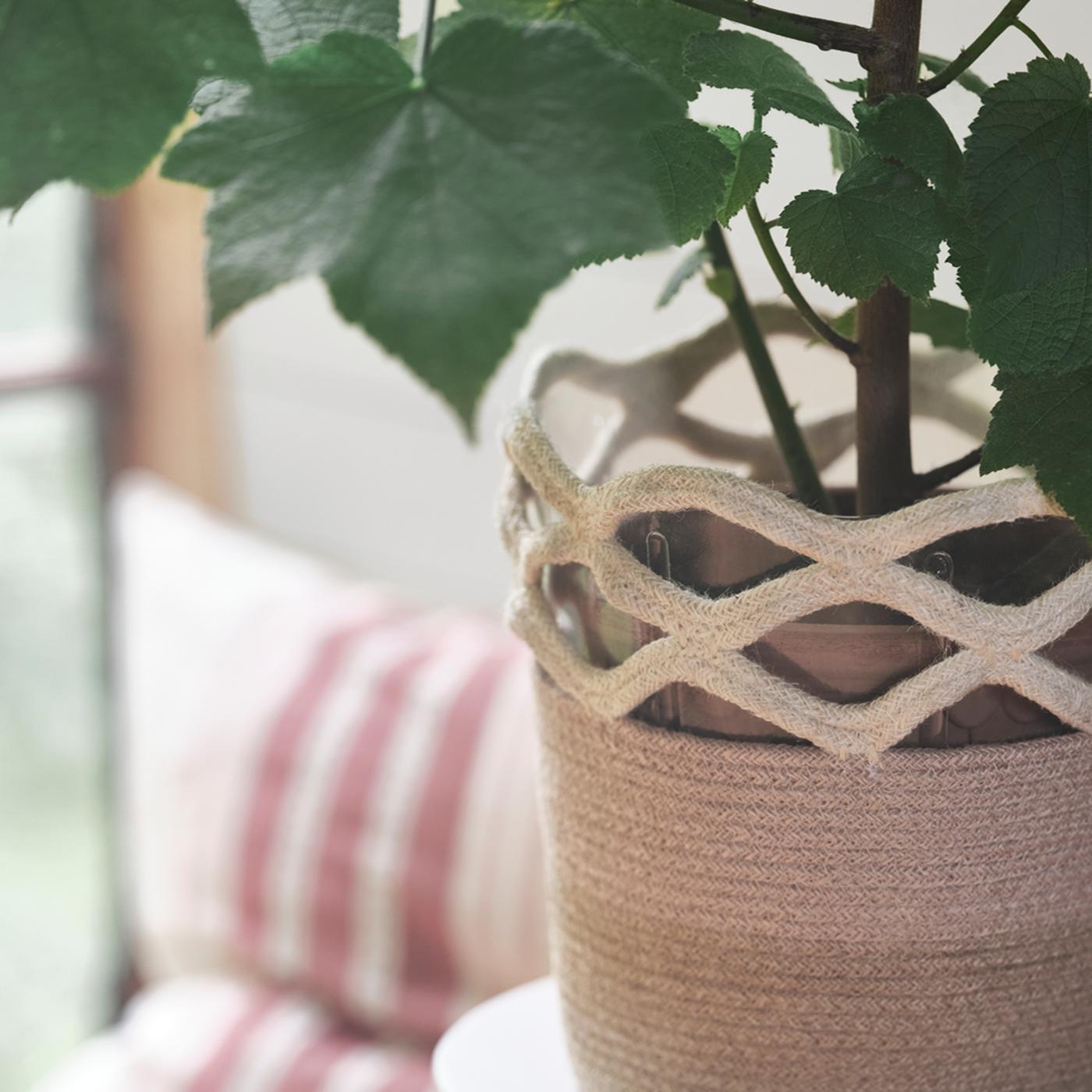 A VÅRDANDE 100% jute plant pot, filled with a leafy green plant, is in focus.