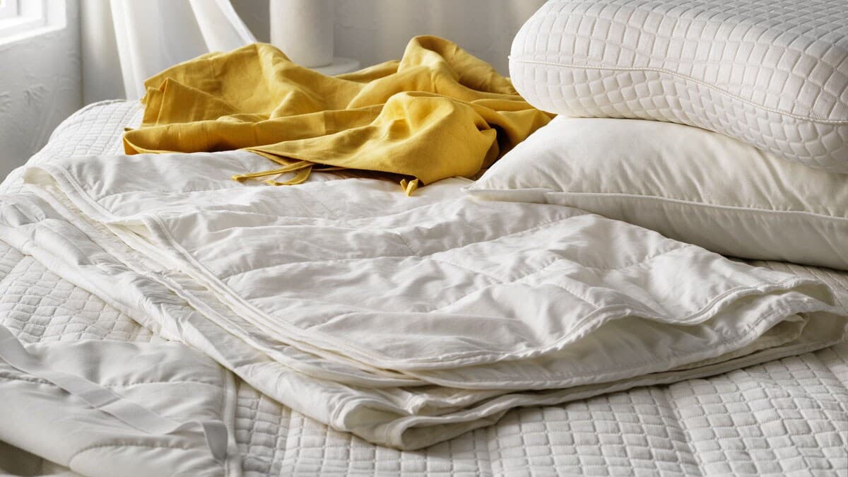 A VÅRSTARR duvetshown lying on a bed.