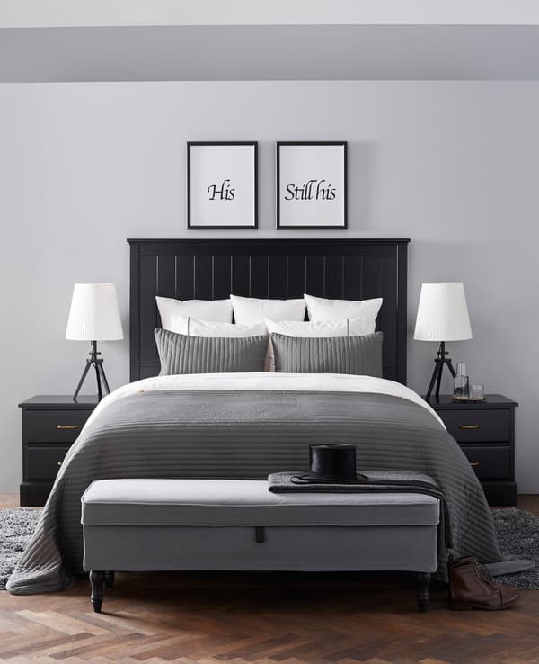 A very neat bedroom in whites, blacks, and greys is reminiscent of a hotel suite.