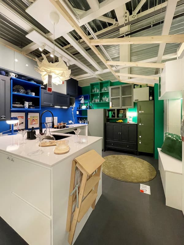 A vibrant and inclusive kitchen with blue and green coloured cabinets.