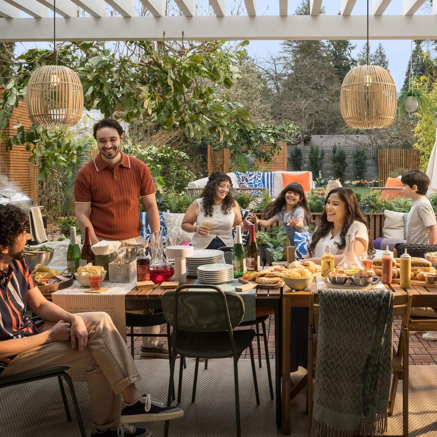 A vibrant outdoor dining table setting with a family gathered around it.