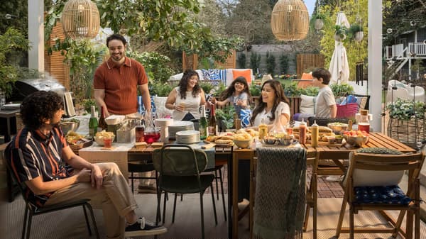 A vibrant outdoor dining table setting with a family gathered around it.