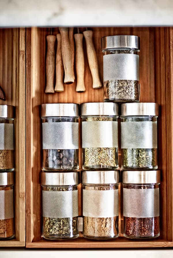 A view from above of herbs stored on an additional shelf in a shallow kitchen drawer.