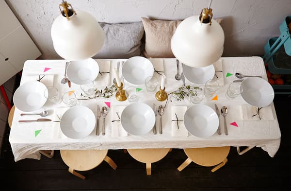 A view from above of the dinner table, fully set with flatware and cutlery.
