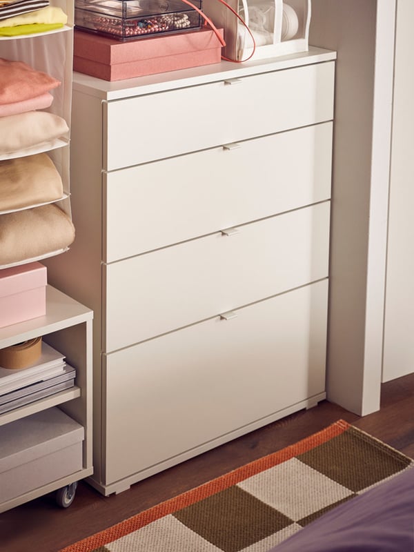 A VIHALS chest of drawers is placed beside other drawers along the wall, at a corner of a bedroom.